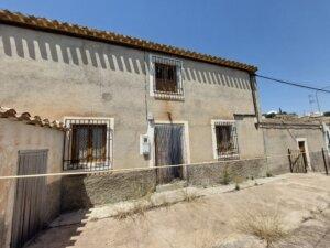 Spanish farmhouse in need of reform against a blue sky